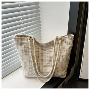 Détail de la texture tissée à carreaux et de la poignée en corde du grand sac cabas