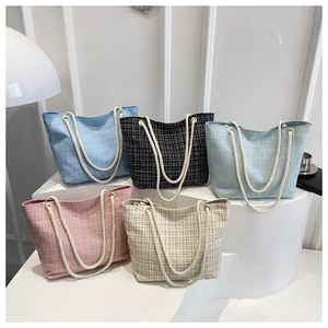 Détail de sacs cabas en tweed avec anses en corde en cinq couleurs sur des marches