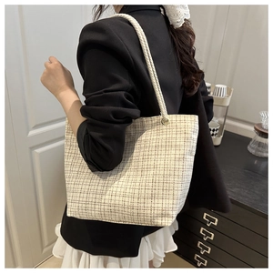 Détail du grand cabas tissé à carreaux beige avec anses en corde épaisse et texture
