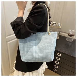 Détail du sac cabas en tweed à carreaux bleu clair avec anses en corde de coton et anneaux