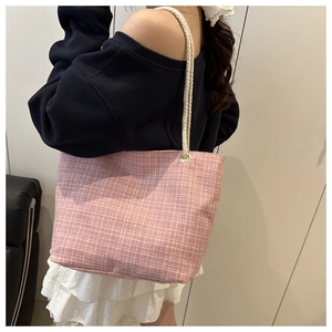 Grand sac cabas rose à carreaux avec anses en corde porté à l'épaule