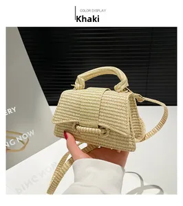 Detail of khaki woven straw handbag showing textured raffia material and top handle