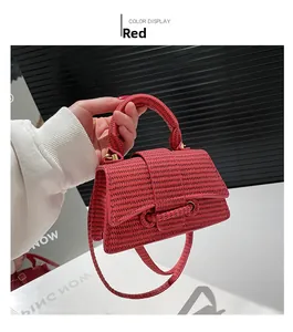 Detail view of red woven texture synthetic leather trapezoid handbag with top handle