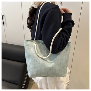 Gros plan du sac fourre-tout bleu clair tissé avec poignées épaisses en coton crème