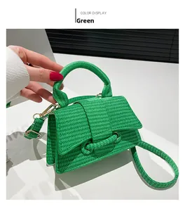 Close-up of bright green woven shoulder bag featuring gold hardware and detachable strap