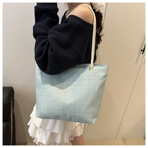 Détail du sac cabas en tweed bleu clair avec anses épaisses en corde de coton blanc