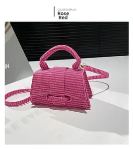 Detail of rose red woven mini handbag with gold hardware and removable shoulder strap