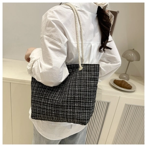 Vue de dos détaillée du mannequin portant un grand sac cabas en toile à damier noir et blanc