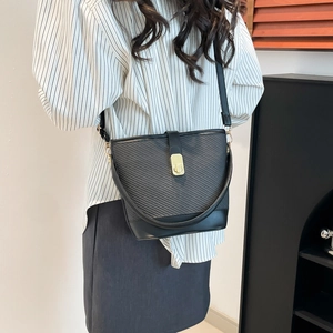 Sac seau noir élégant avec surpiqûres contrastées et fermoir doré dans un décor de style de vie
