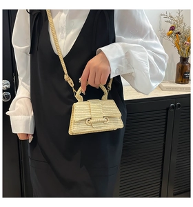 Close-up of the beige woven texture and buckle detail on this vintage crossbody handbag