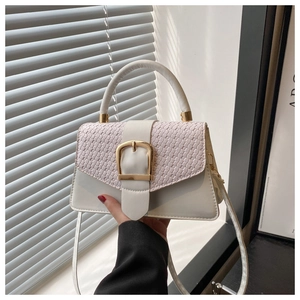 Detail of white and purple textured crossbody bag with a large gold buckle and strap