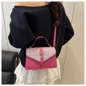 Close-up of pink leather handbag with glittery sequin flap and gold buckle hardware