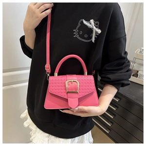 Detailed close-up of the woven texture flap and golden buckle on this pink mini bag