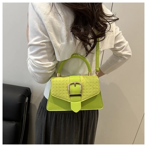 Detail showing animal embossed texture and gold buckle on a lime green handbag