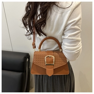 Brown retro square shoulder bag with woven texture and gold buckle shown on model