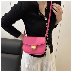 Gros plan du sac besace en cuir rose avec un élégant fermoir en métal doré carré