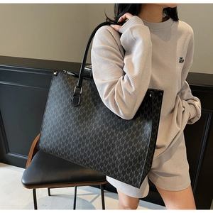 Chic large tote bag with M-pattern print shown in a stylish modern lifestyle setting