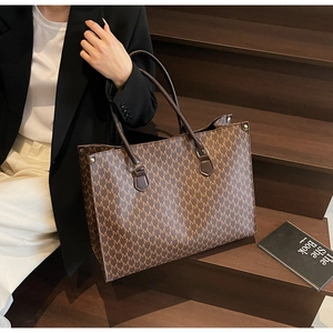 Close-up of retro dark brown tote bag with M letter pattern on wooden steps