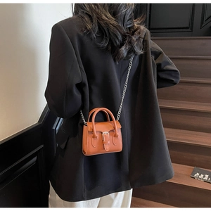 Détail du mini sac carré marron caramel avec chaîne argentée et boucle de ceinture