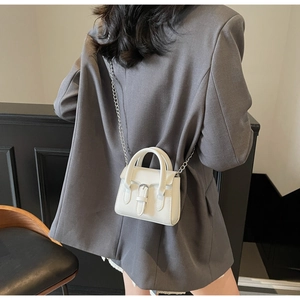 Mini sac bandoulière blanc en cuir avec chaîne argentée sur blazer gris