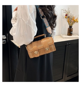 Brown faux leather crossbody bag with dual turn-locks and colorful embroidered wide strap