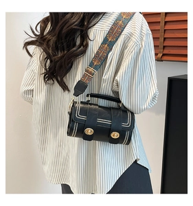 Detailed view of black Boston bag with pearl studs and embroidered wide strap