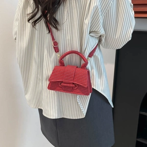 Elegant red woven trapezoid handbag with structured handle and adjustable strap for women