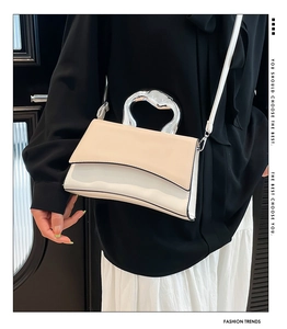 Detail of artistic silver metal handle and cream-white patchwork on small square bag