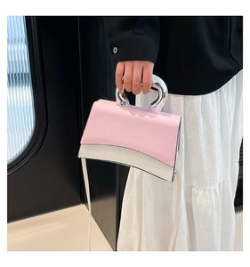 Detail of fashion crossbody bag with pink flap and silver metal handle