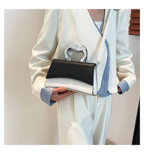 Detail of the liquid metal silver handle on a black and white square crossbody bag