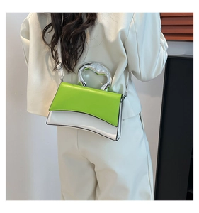 Rear view of a model wearing the green and white contrast leather bag with silver handle