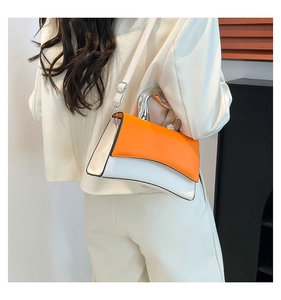 Detail of the orange and white crossbody bag with curved silver metal handle