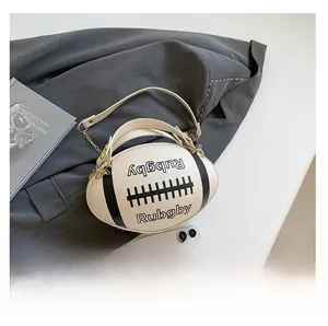 Detail of rugby-shaped crossbody bag in cream PU leather on a grey blazer suit