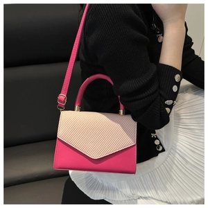 Detail of pink and beige patchwork handbag with woven texture and gold metal buckle