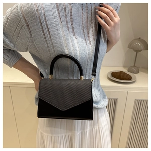 Detail of contrast stitch mini crossbody bag with round handle and gold hardware