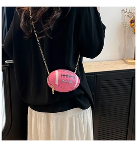Detail view of pink rugby-shaped mini crossbody bag with gold chain strap on model