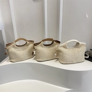 Three minimalist woven straw handbags with rounded top handles and detachable shoulder straps