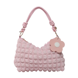 Pink quilted bubble crossbody bag with knotted handle and floral charm pendant
