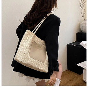 Detail of woven straw tote bag with faux leather pocket and stylish rope straps