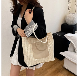 Detail view of woven straw tote bag featuring leather patch and rope handles