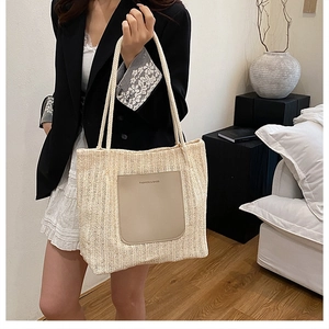 Détail du sac cabas d'été en paille avec texture tissée beige et poche en cuir