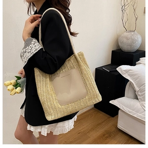 Detail of hand-woven straw tote bag with leather logo patch and cotton rope handles