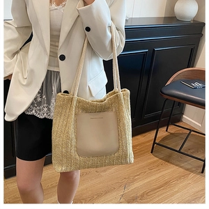 Detail of light beige woven tote bag with leather pocket and rope handle on model