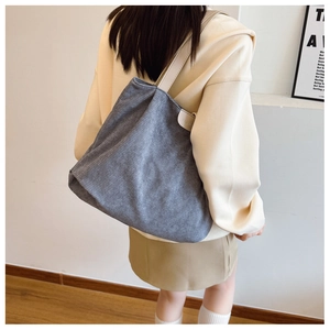 Detail of grey corduroy tote bag featuring a vertical texture and fashion leather patch