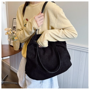 Detail of black corduroy tote bag showing textured material and spacious capacity