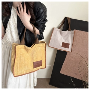 Detail von Cord-Tragetaschen in Gelb und Beige mit modischen Kunstleder-Labels