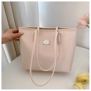Détail du sac cabas beige rose avec une plaque en métal argenté et quatre rivets