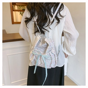 Floral drawstring backpack with blue plaid bow detail shown from a back perspective