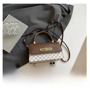 Detail view of vintage contrast crossbody bag featuring retro monogram and gold clasp