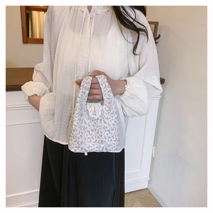 Detail der Blumen-Eimertasche mit Spitzenverzierung in einer Lifestyle-Umgebung